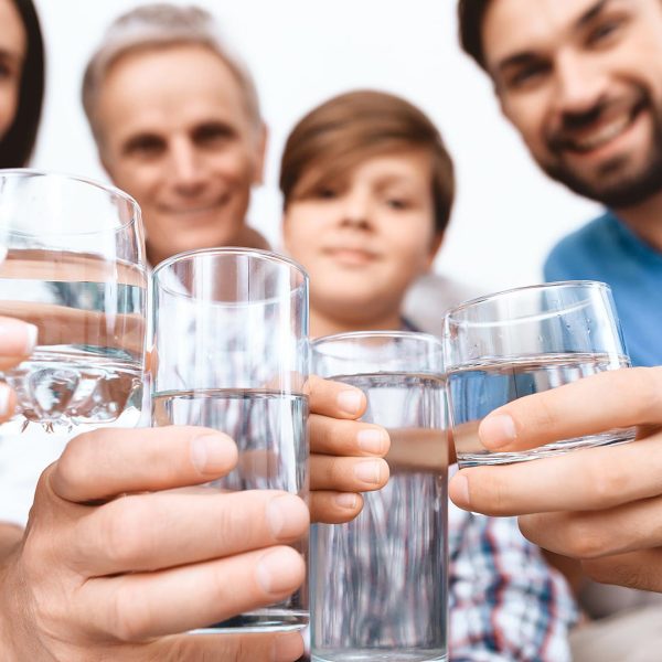 Close up. Cheerful Family cheering with glasses of water.